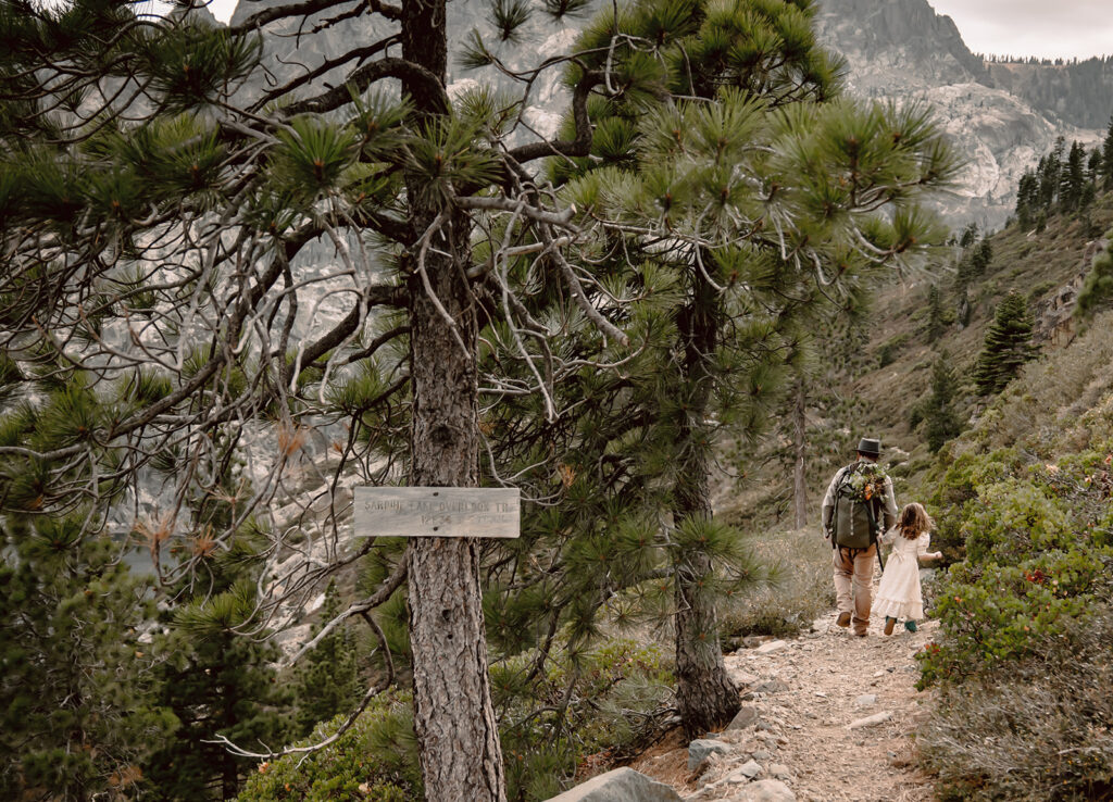 a groom and his daughter hiking on their elopement day