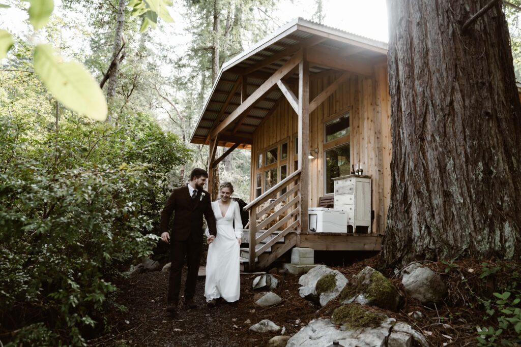 a bride and groom leaving their airbnb in the woods for their elopement day