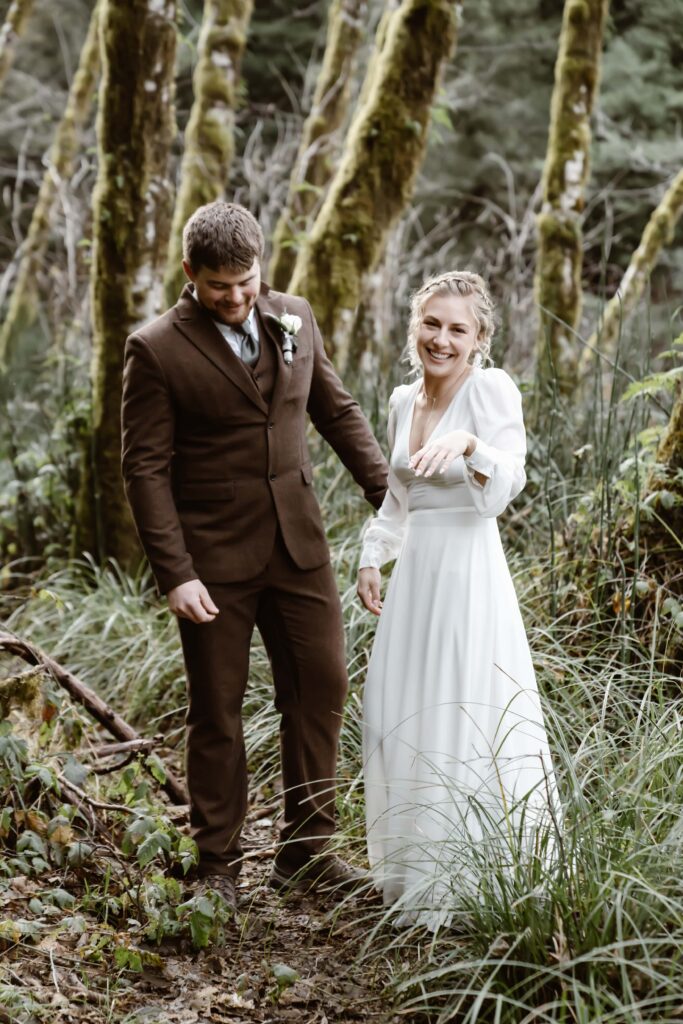a wedding couple standing in front of mossy trees in the rainforest of northern california