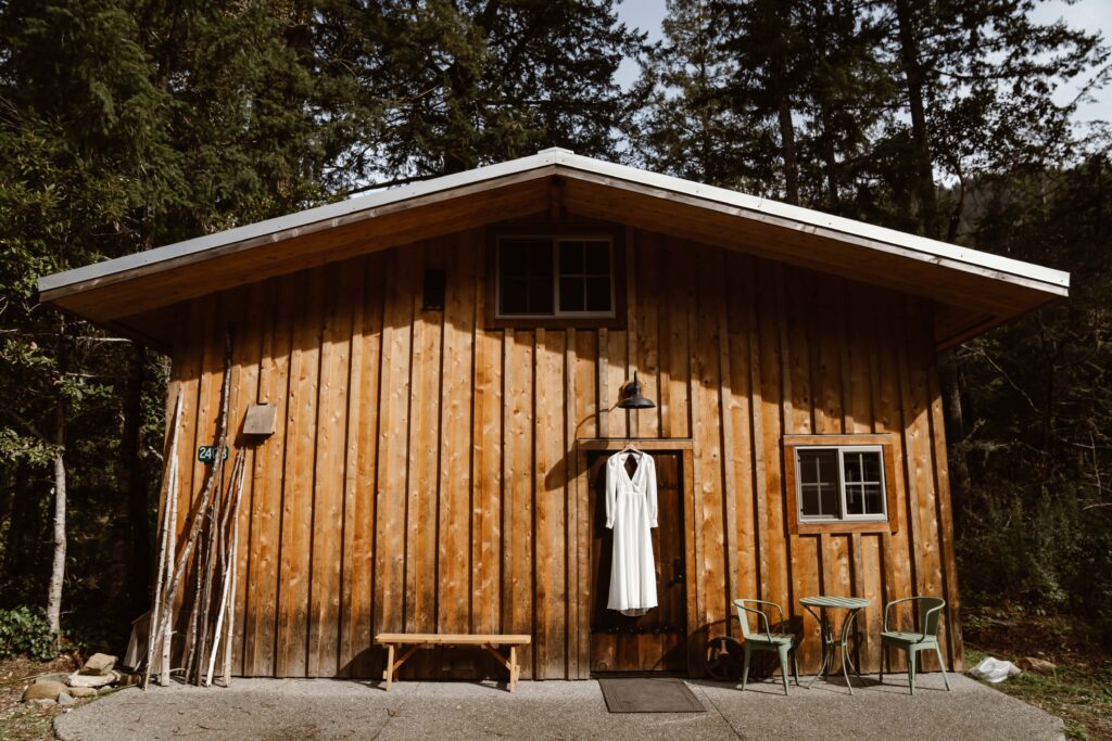 A wedding dress hanging on the door to an airbnb for an elopement day in Northern California
