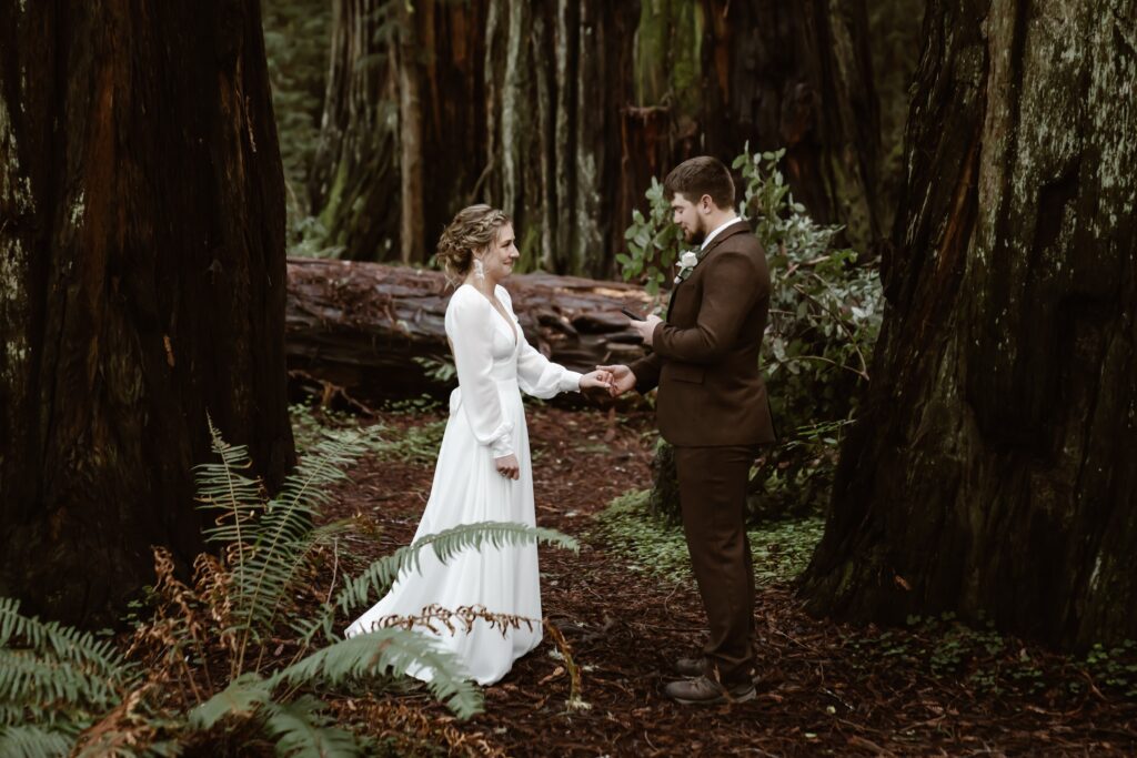 A couple reading private vows to each other on their elopement day in the Redwood Trees