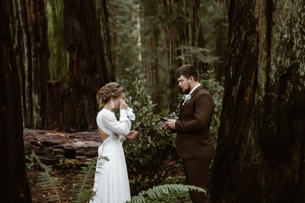 a bride wiping her tears during their vow at their elopement ceremony in the redwoods