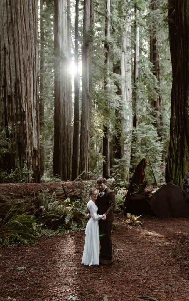 A couple doing their first dance in the redwoods for their elopement day
