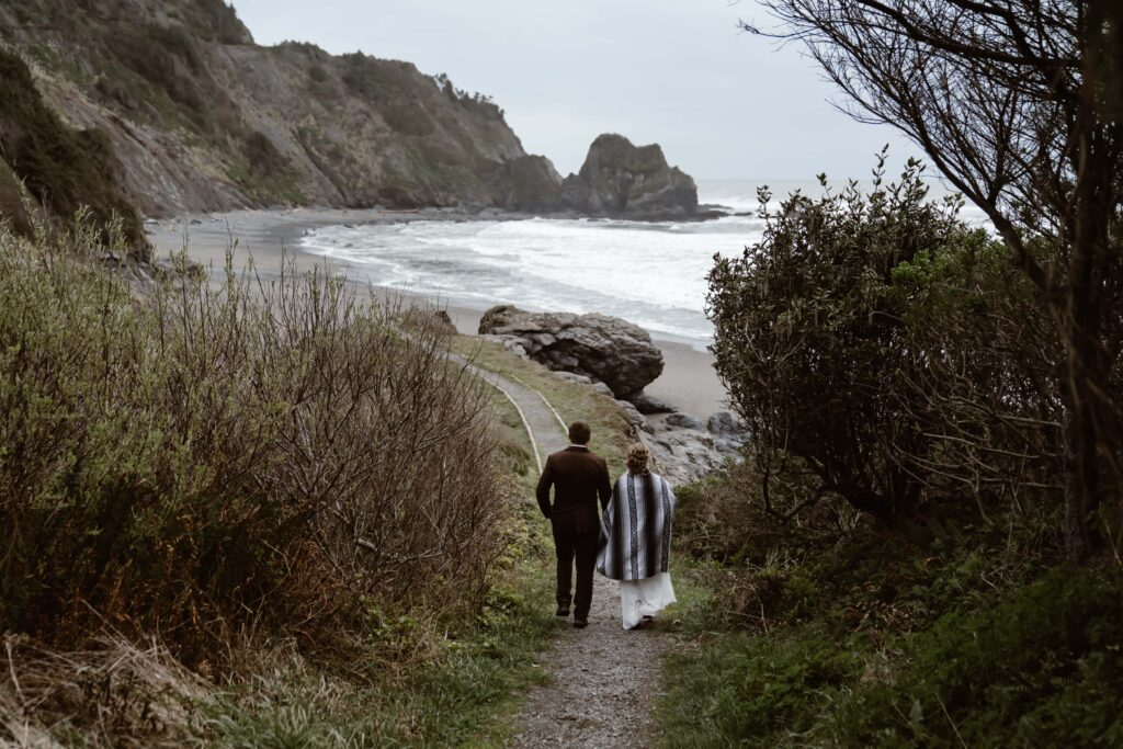 a wedding couple walking down the trail to Enderts Beach 