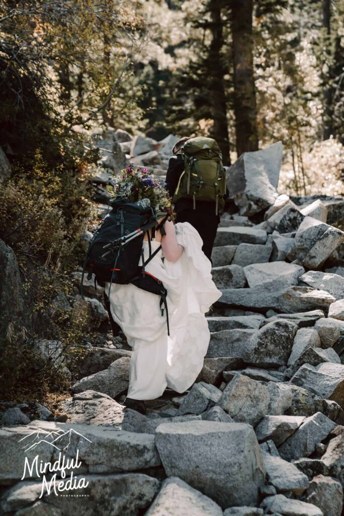 A wedding couple hiking the Eagle Lake Trail in the ir wedding attire for their elopement day