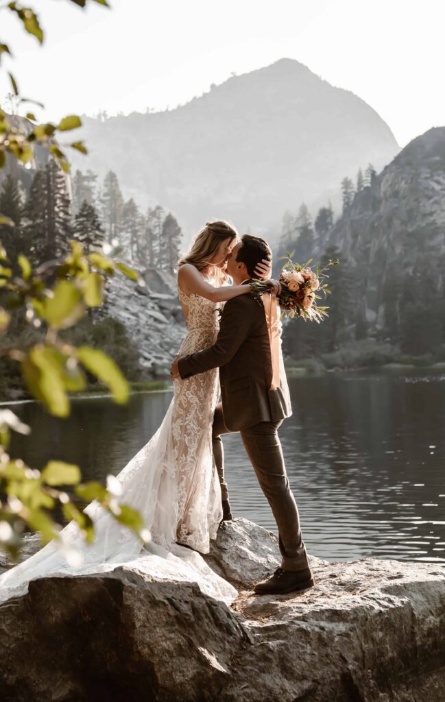 A wedding couple kissing and standing in front of the mountain on their elopement day in Lake Tahoe