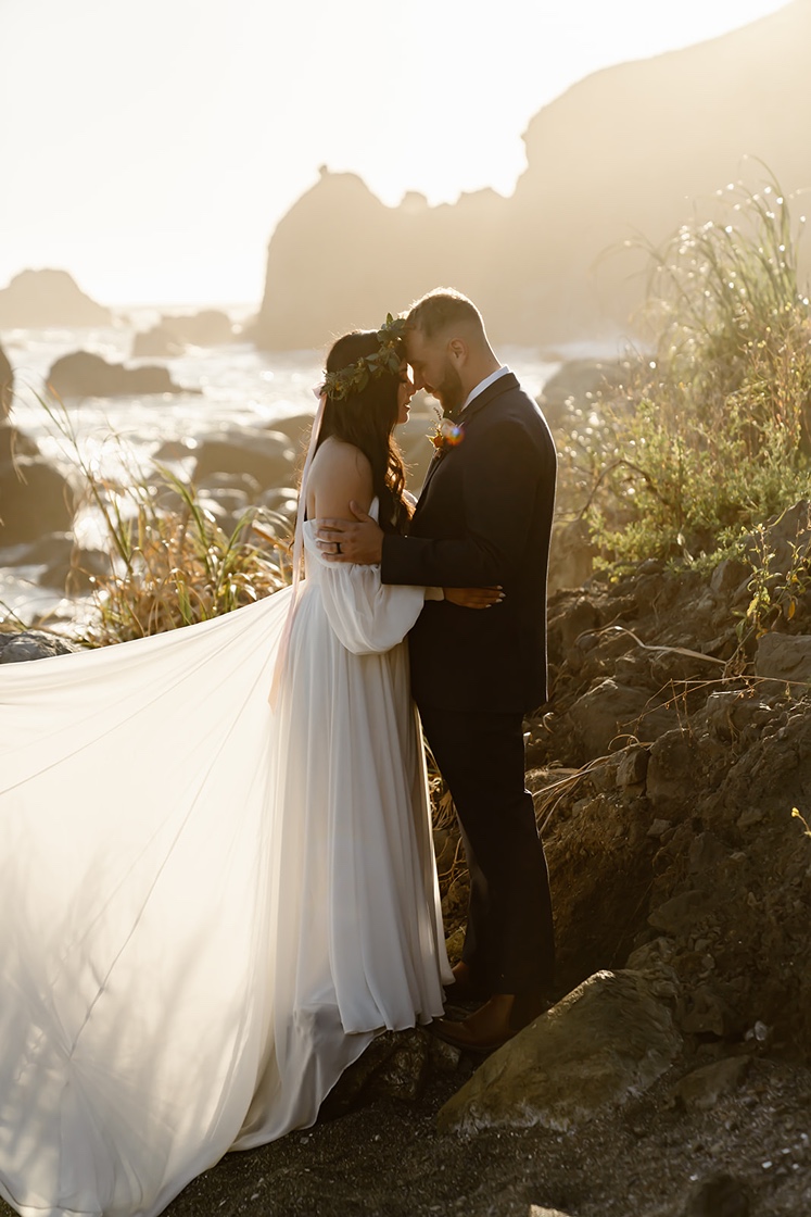 Bride and groom smile at each other during Shell Beach elopement photos