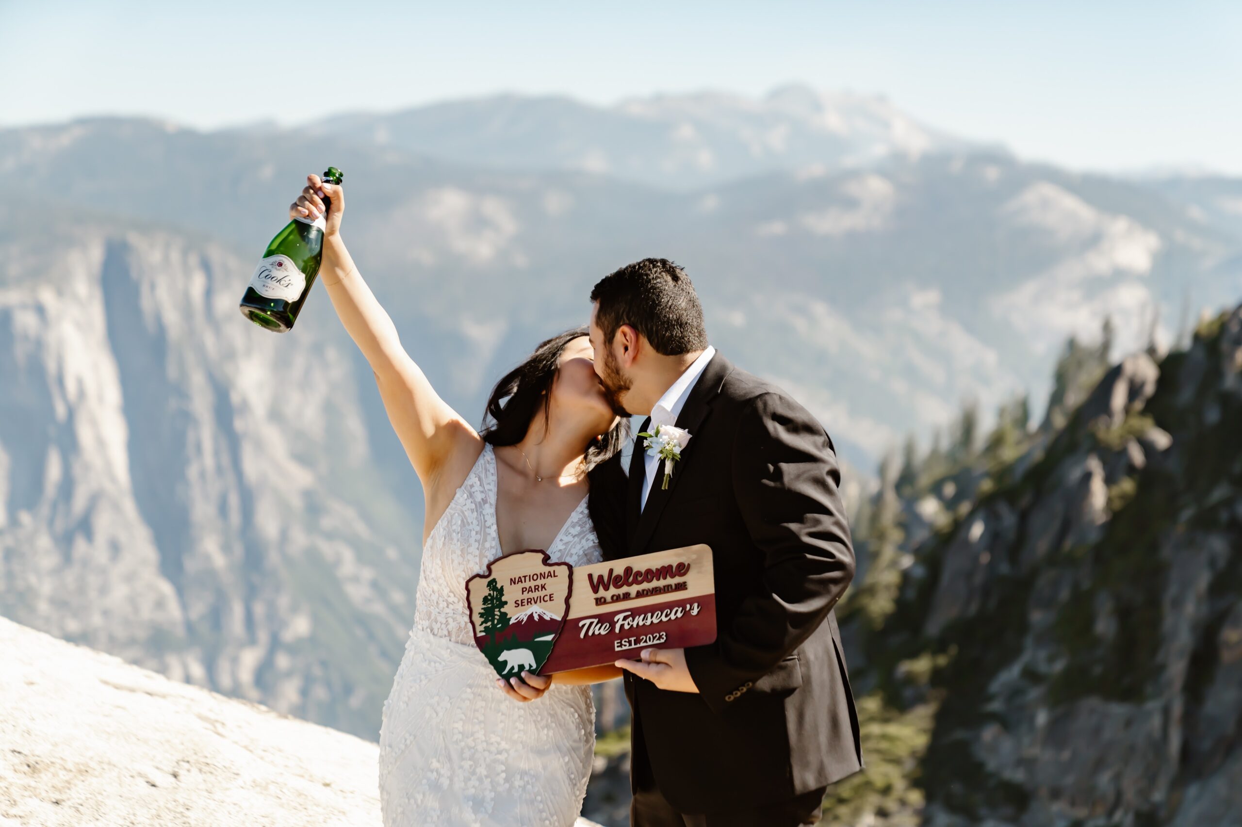 Bride and groom pop champagne at adventure wedding