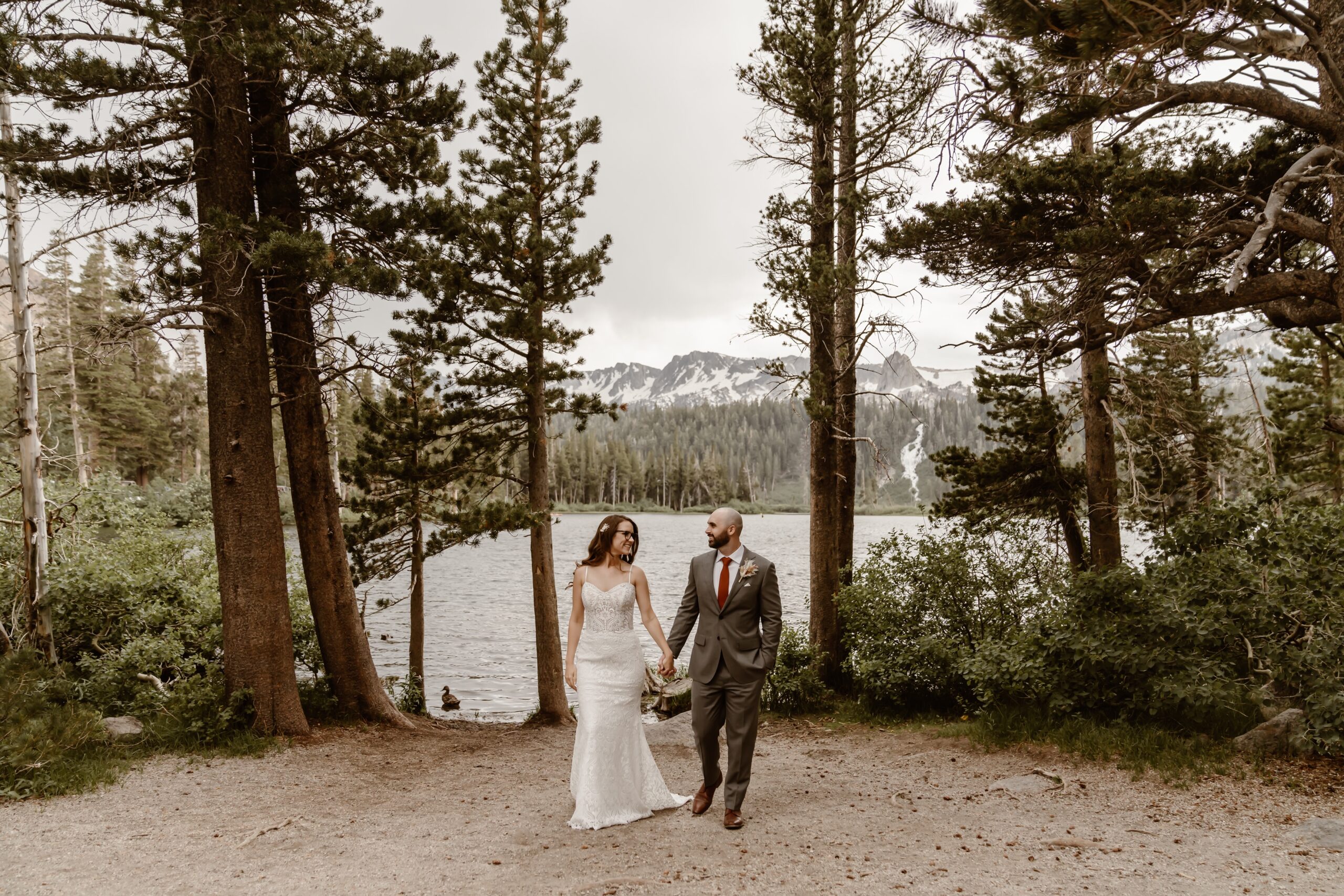 Bride and groom hold hands with Mammoth Lakes backdrop