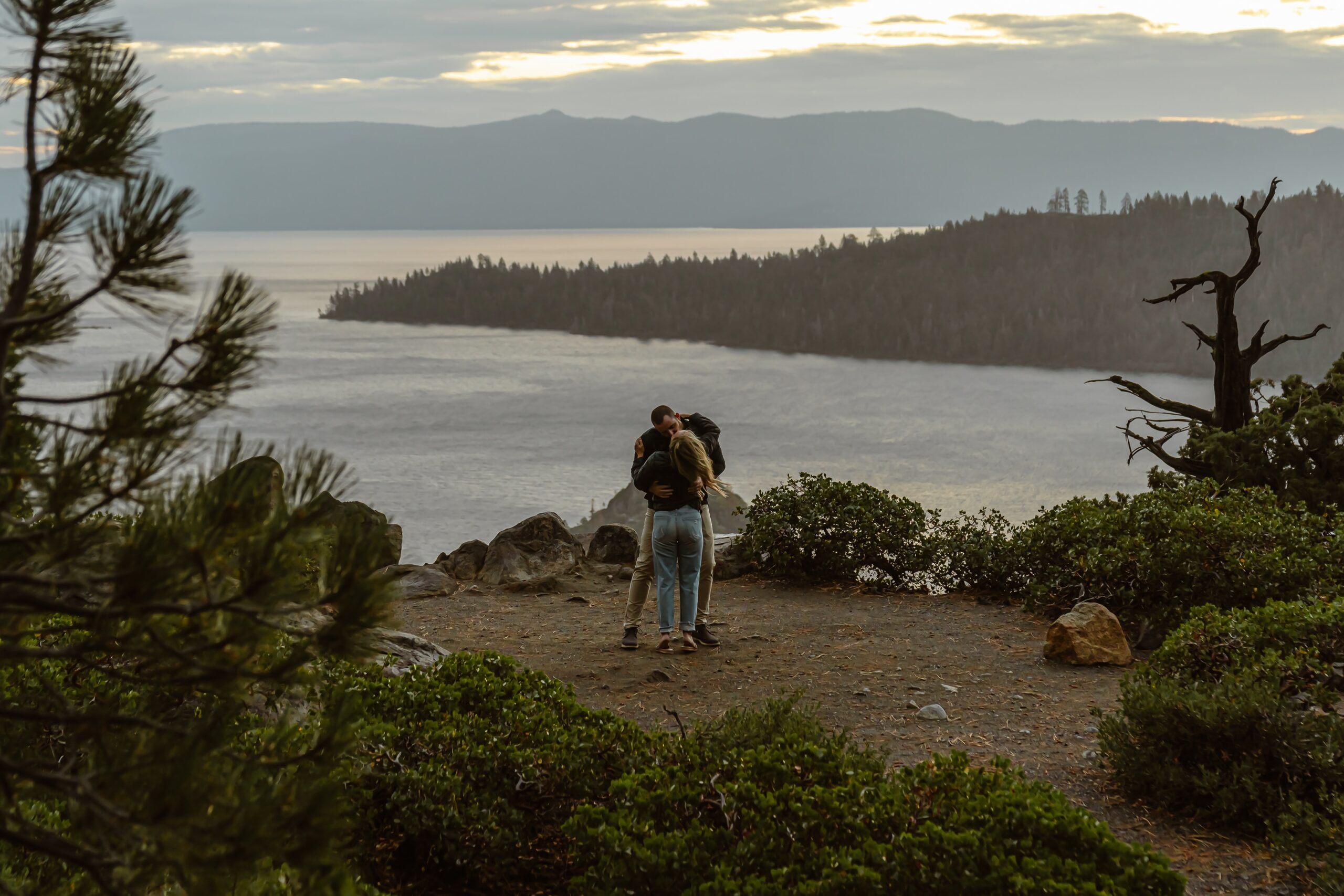 Man and woman hug with Lake Tahoe backdrop
