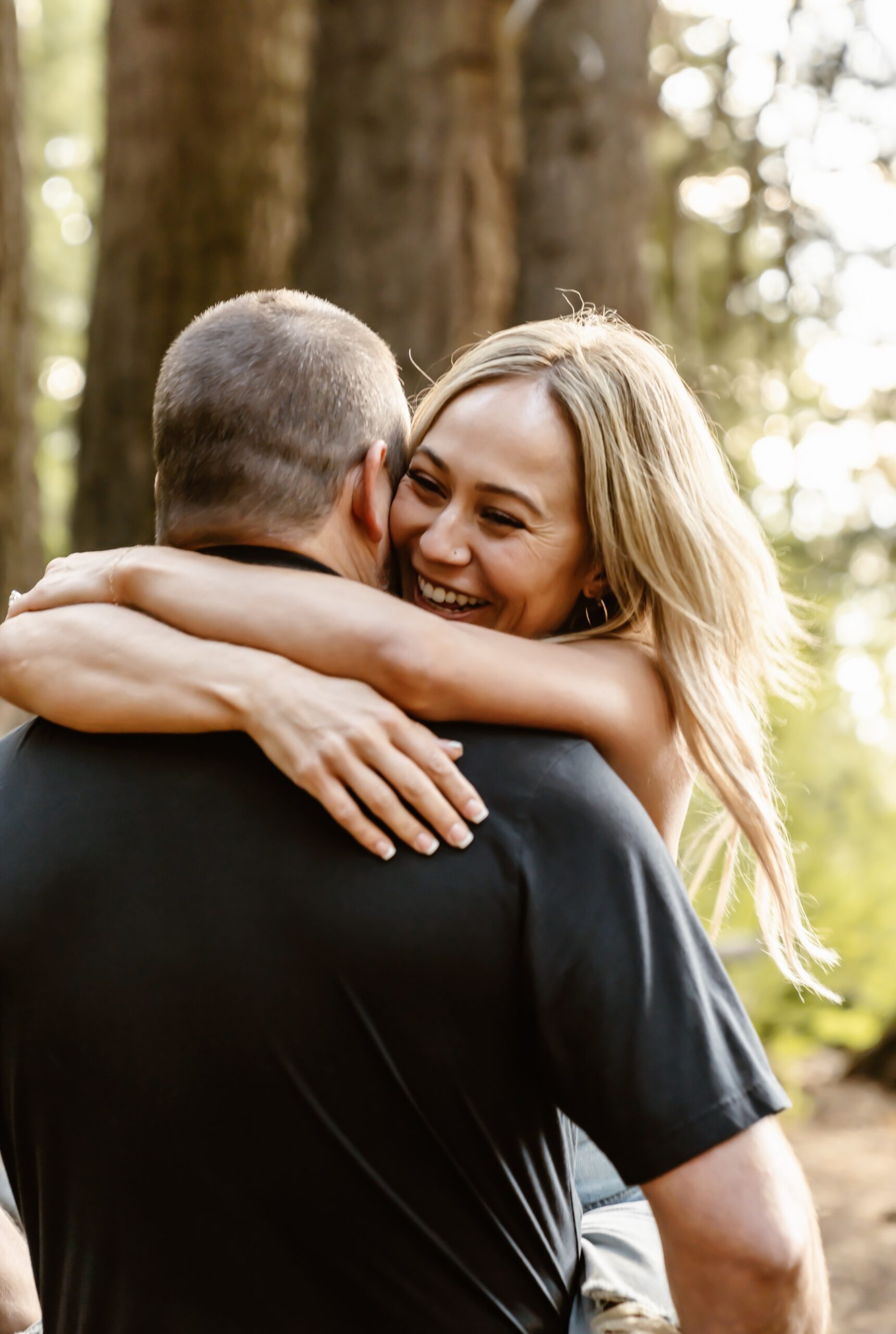 Man and woman hug at Lake Tahoe proposal