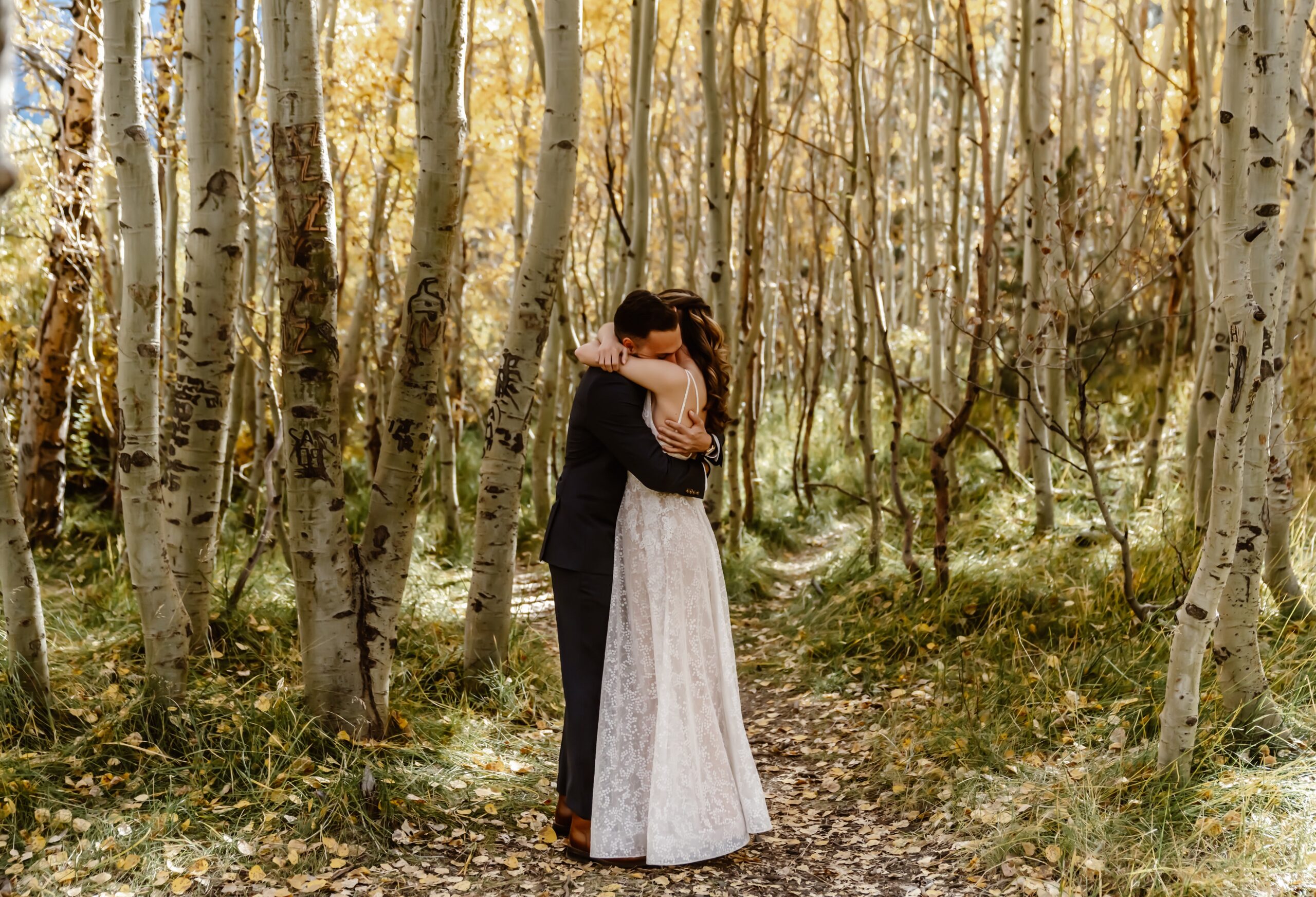 Bride and groom hug in the forest