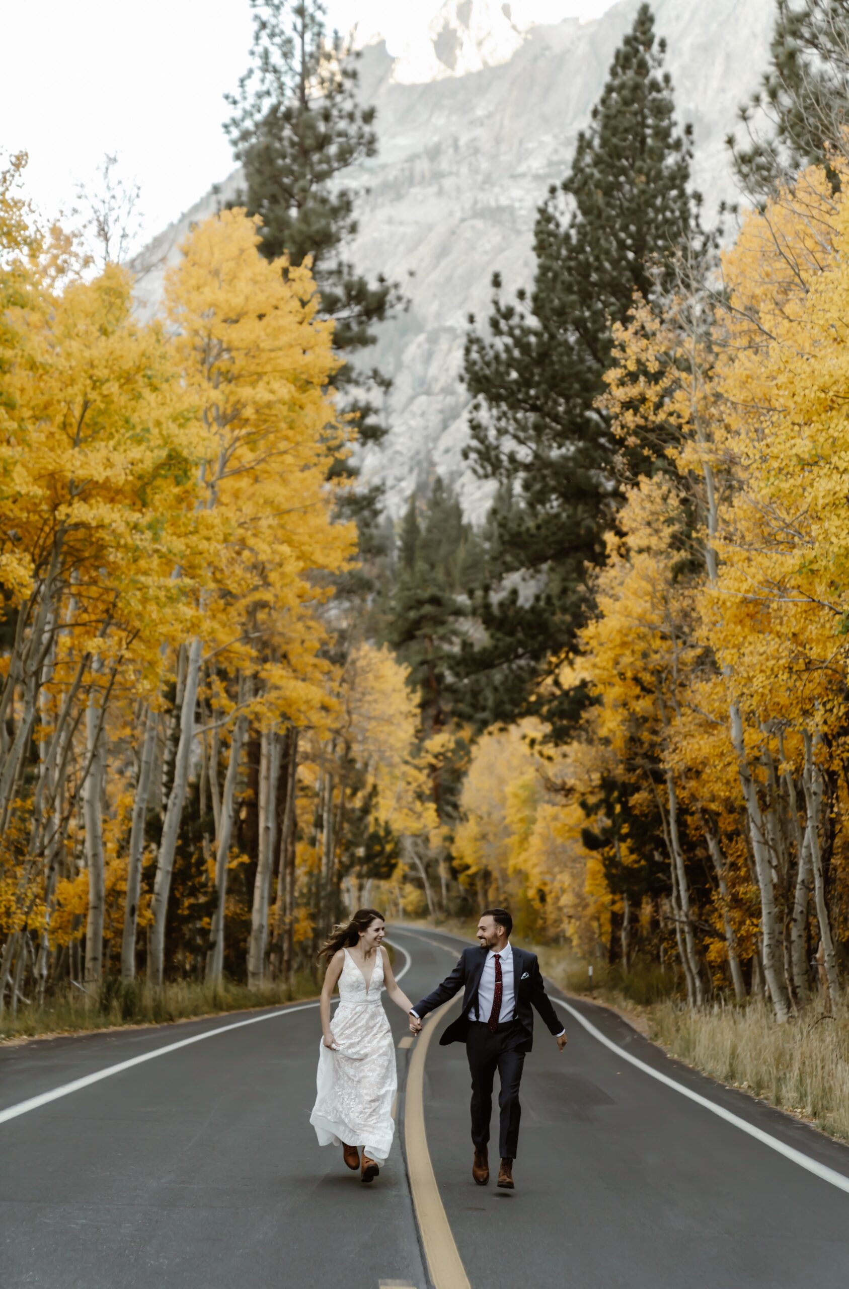 Bride and groom walk along road in Mammoth Lakes