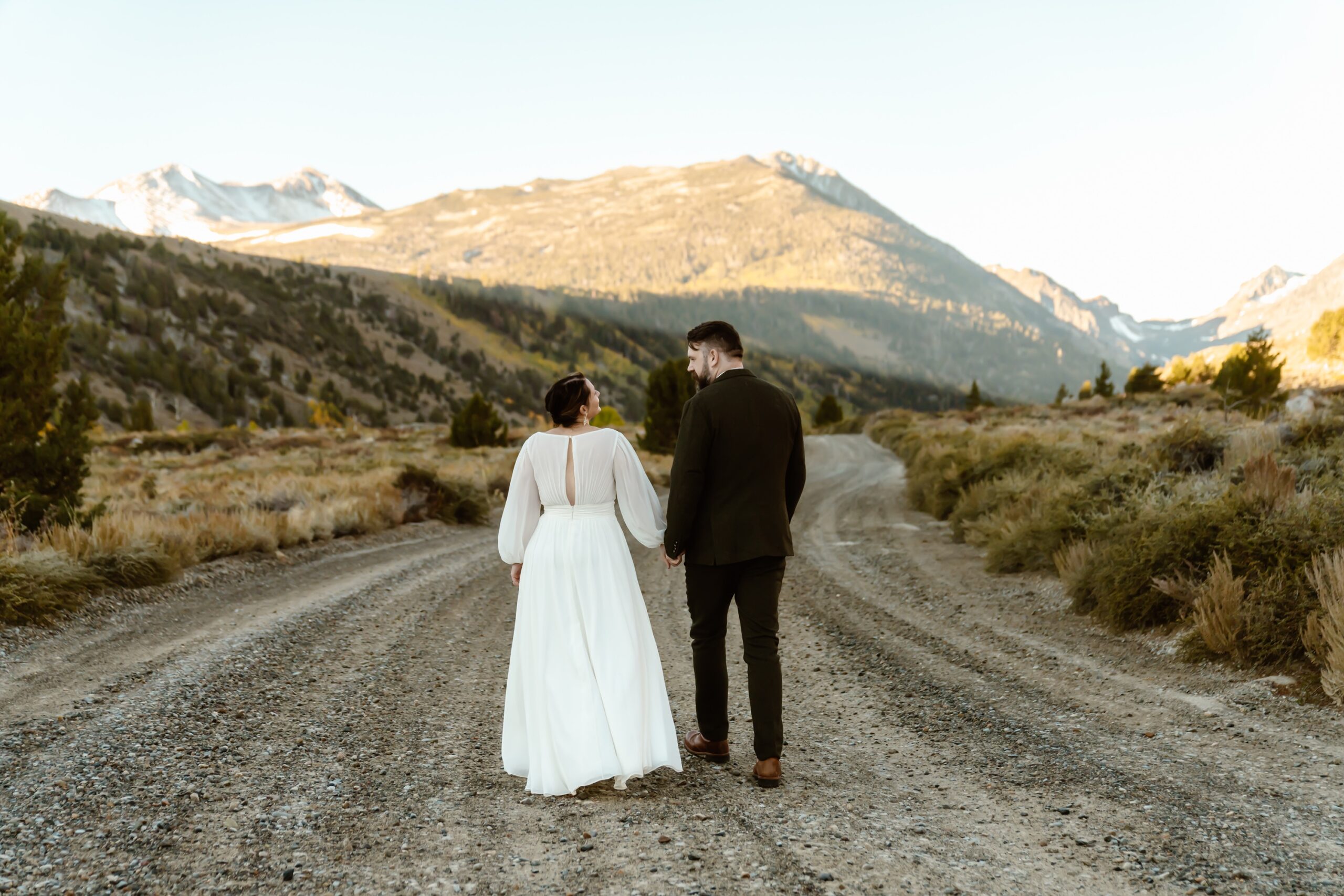 Couple holds hands at sunrise elopement near Mono Lake