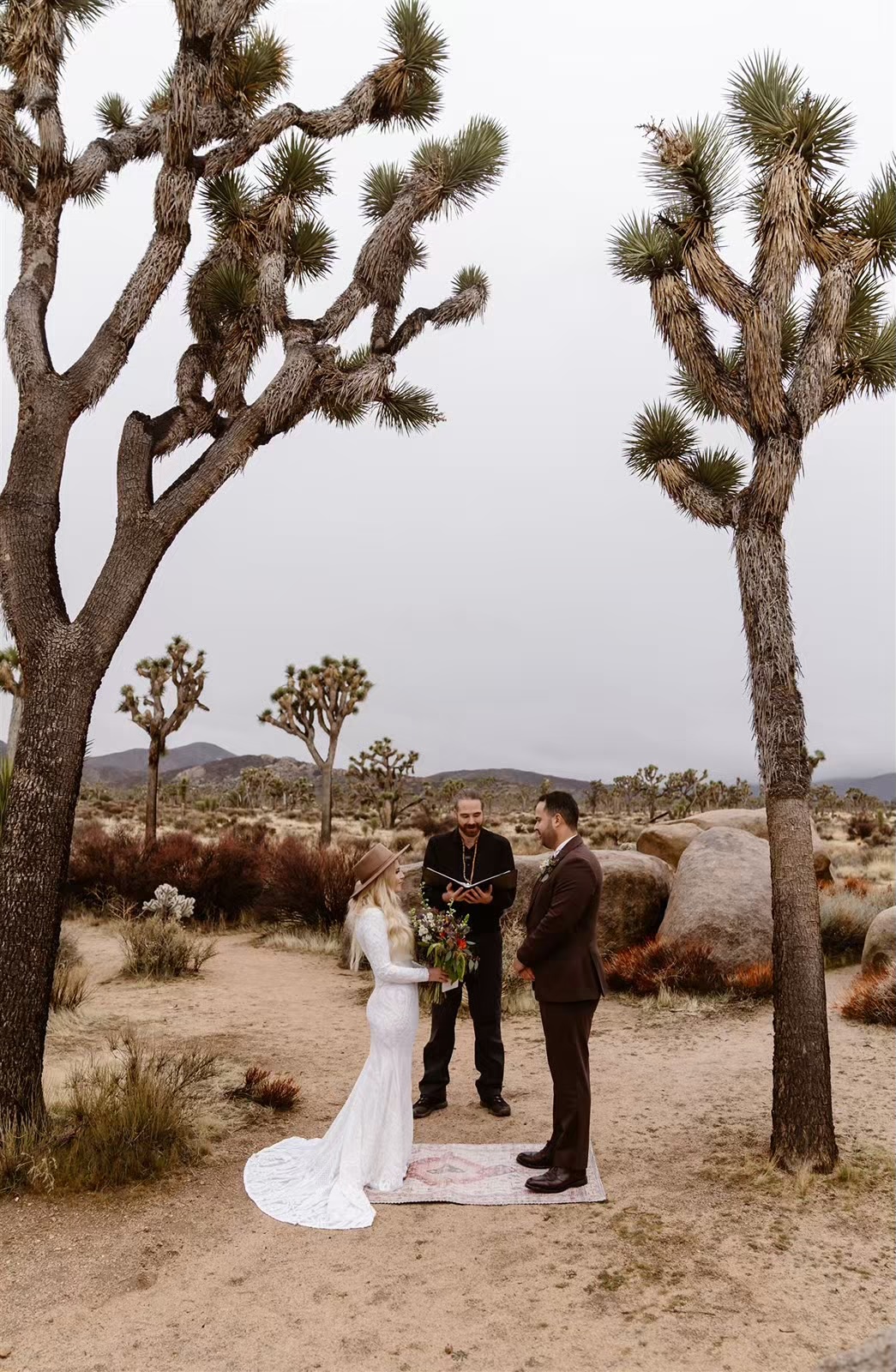 Bride and groom with officiant at Joshua Tree elopement ceremony