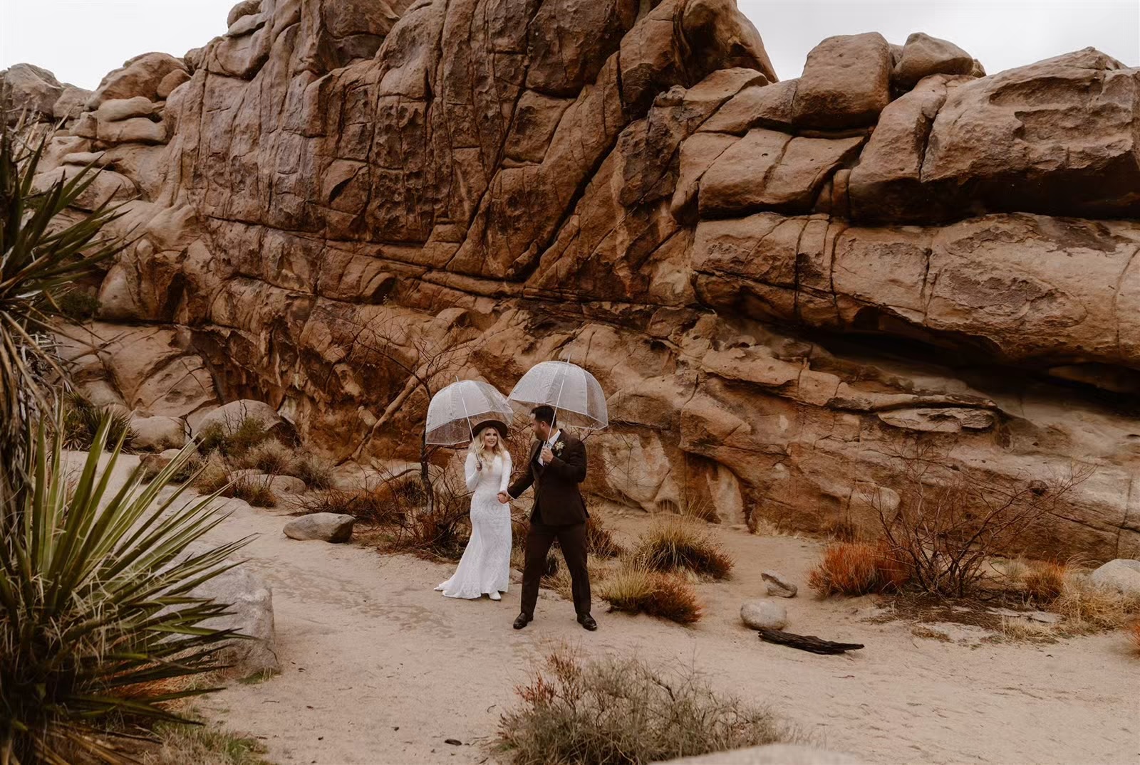 Bride and groom pose for Joshua Tree elopement photos with umbrellas