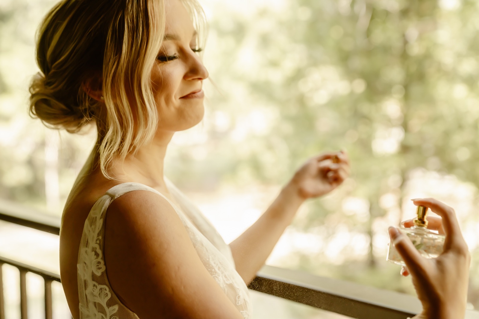 Bride sprays perfume while getting ready for Cathedral Beach Yosemite wedding