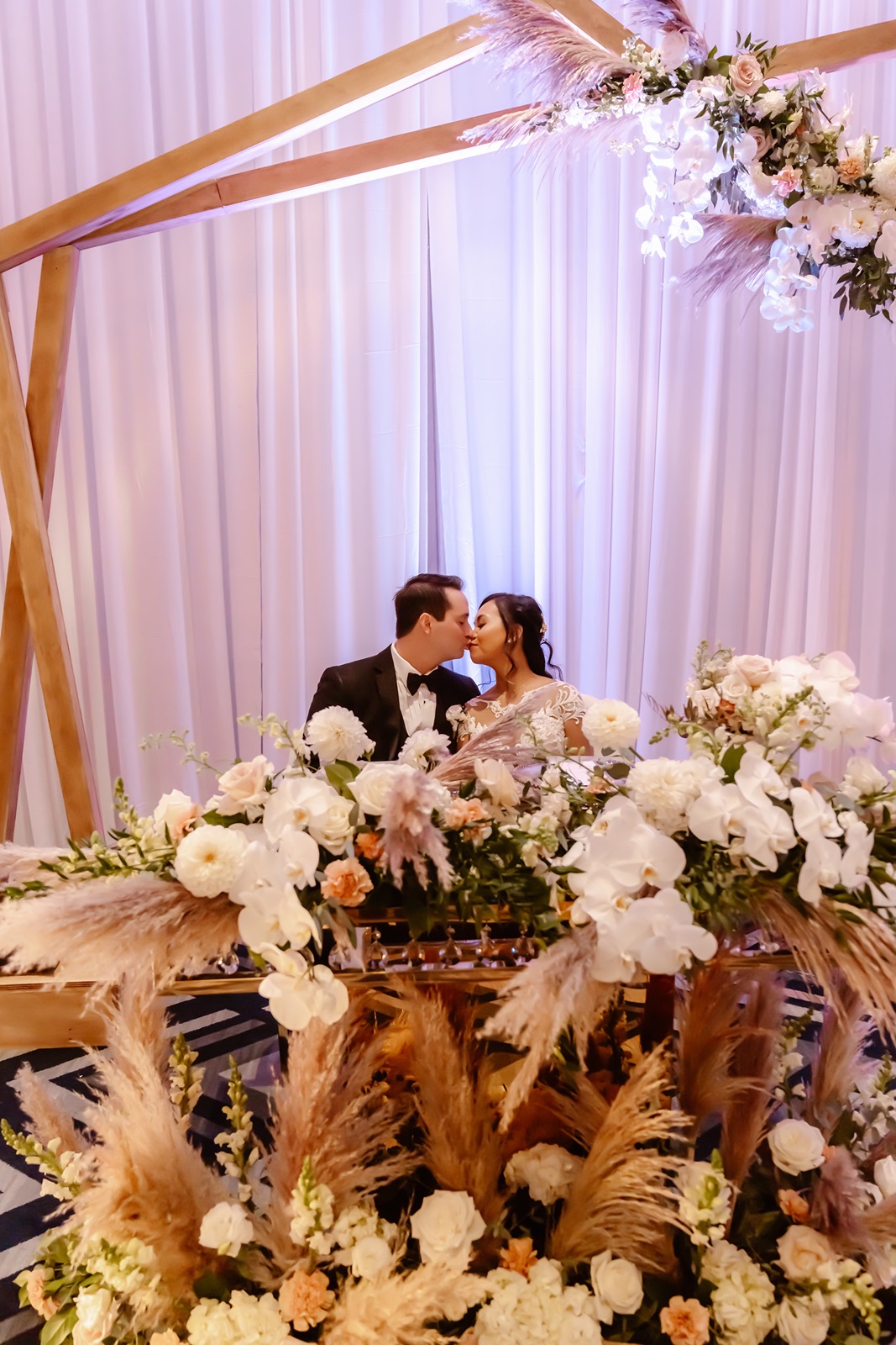 Bride and groom kiss at their sweetheart table at the Everline Resort wedding reception