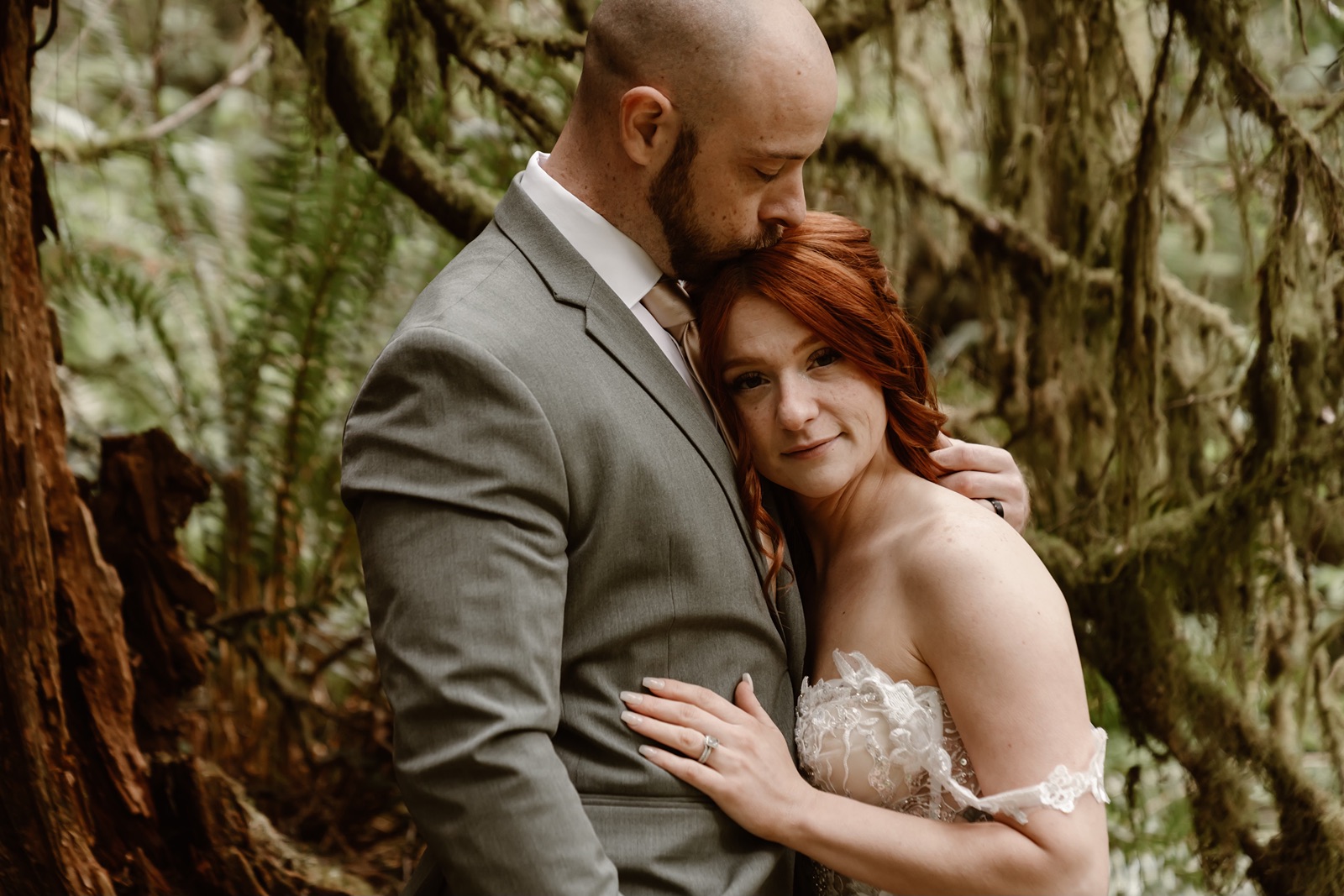 Man kisses woman on head during portraits at their Fern Canyon elopement