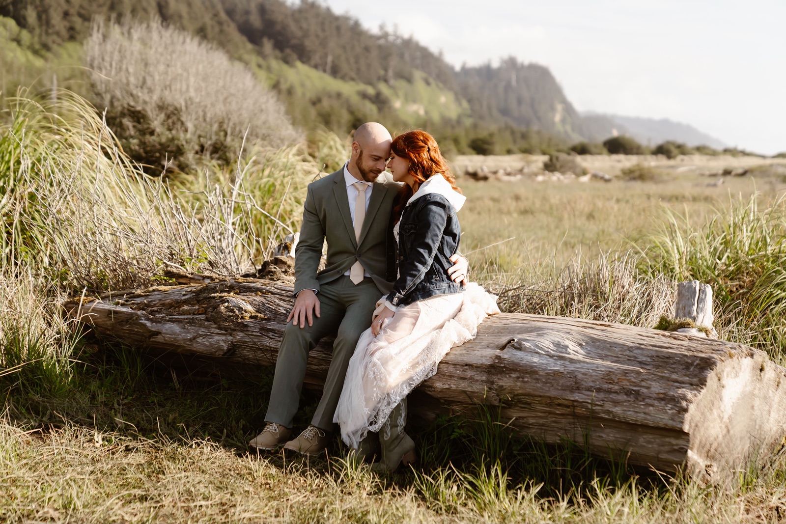 couple sits on log at Gold Beach elopement