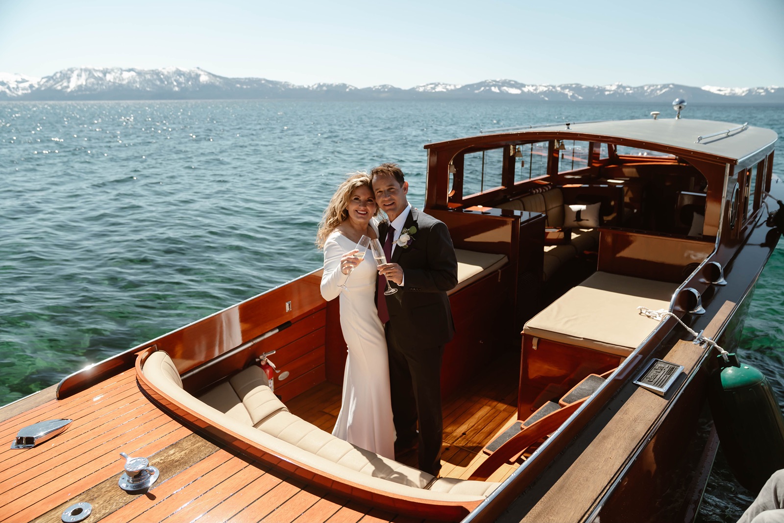 Bride and groom with champagne glasses at their Lake Tahoe boat wedding