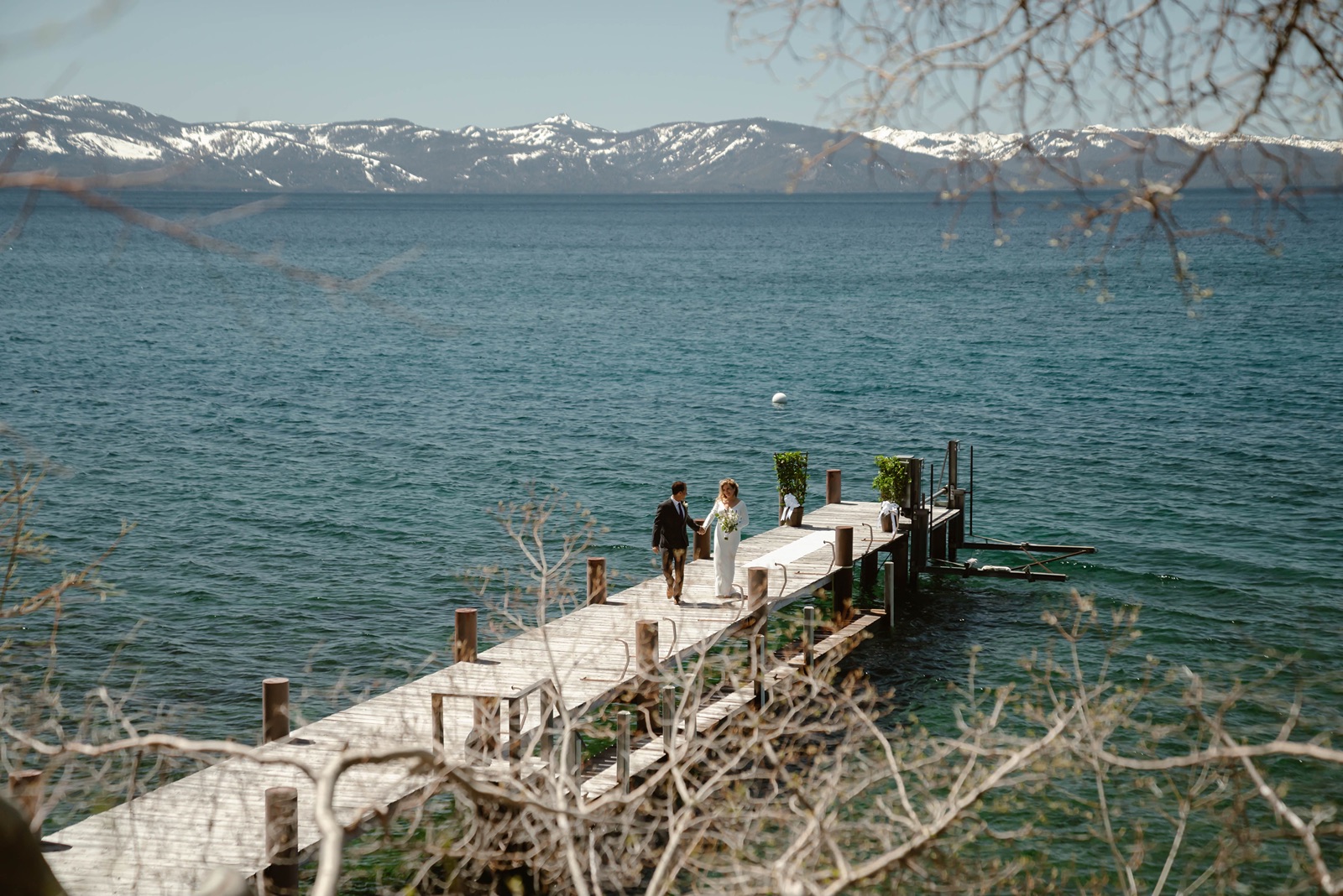Bride and groom walk on pier at Lake Tahoe