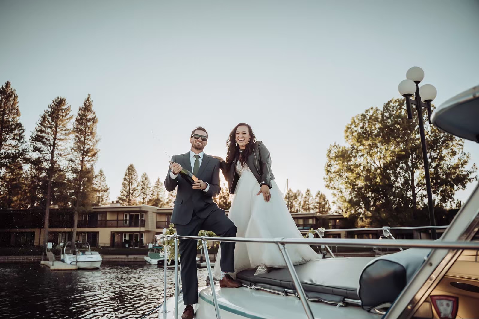 Couple pops bottle of champagne at their Lake Tahoe boat wedding