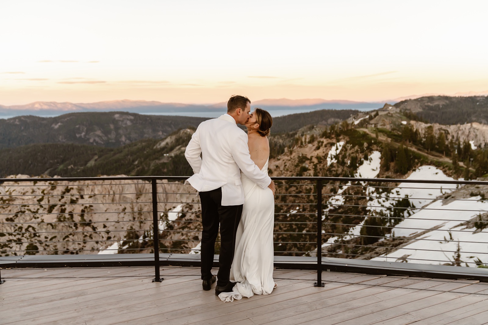 Bride and groom kiss overlooking Palisades Tahoe