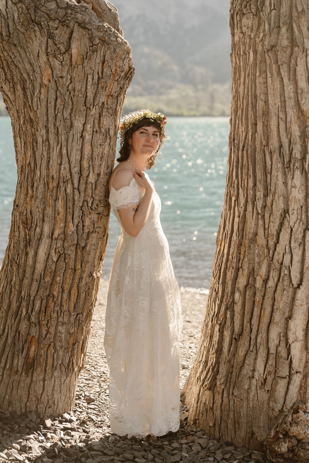 Bride smiles between two trees during bridal portraits at the Convict Lake Resort wedding