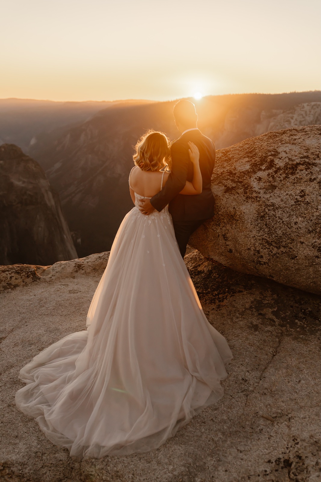 Couple with their backs to the camera admiring the Yosemite sunset
