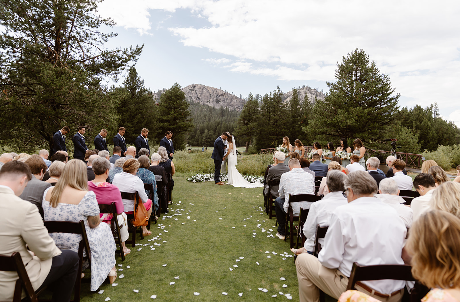 Bride and groom kiss at their outdoor wedding ceremony