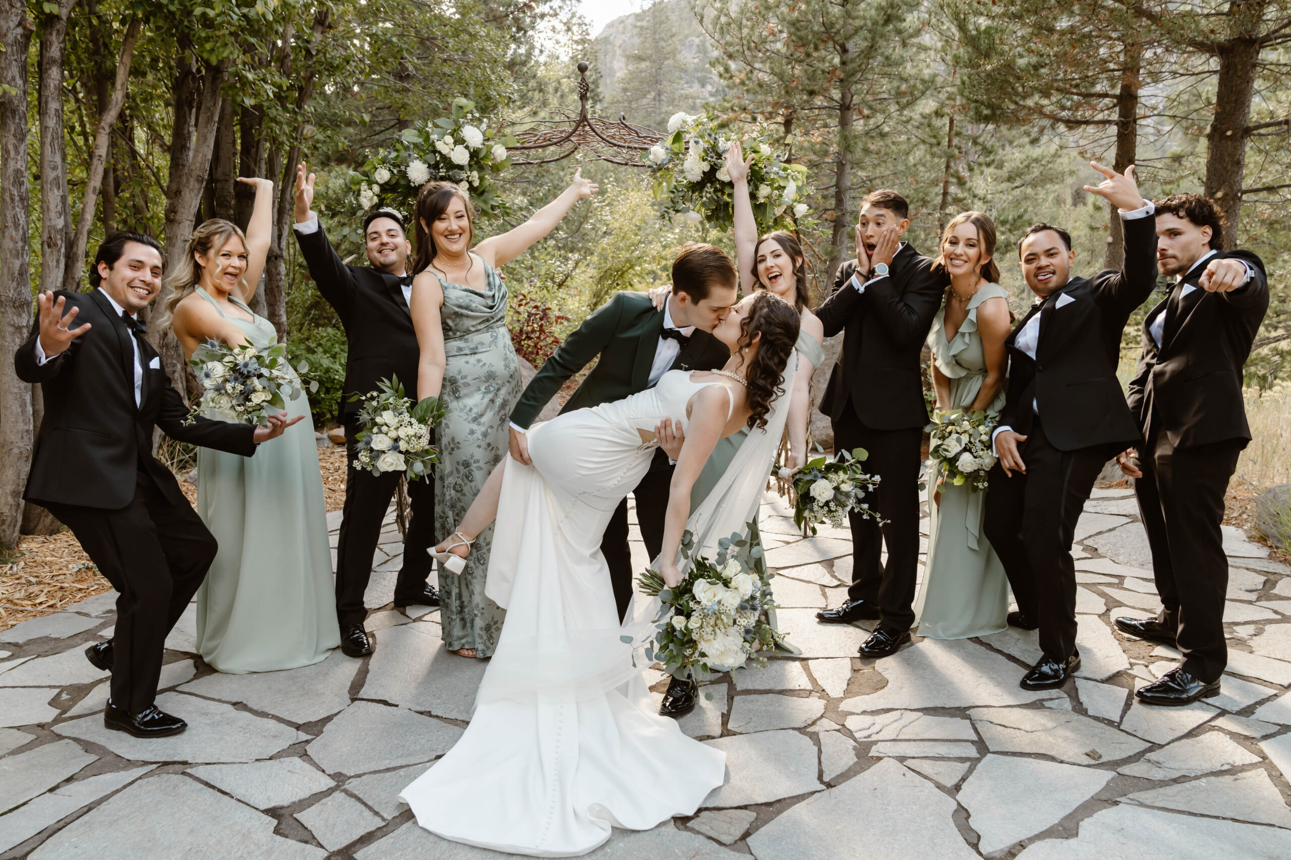 Bride and groom kiss as their wedding party celebrates