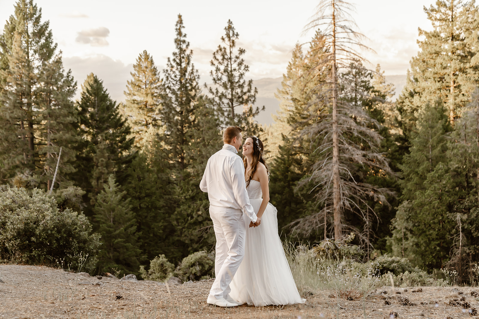 Bride and groom smile at each other at beautiful vista in California