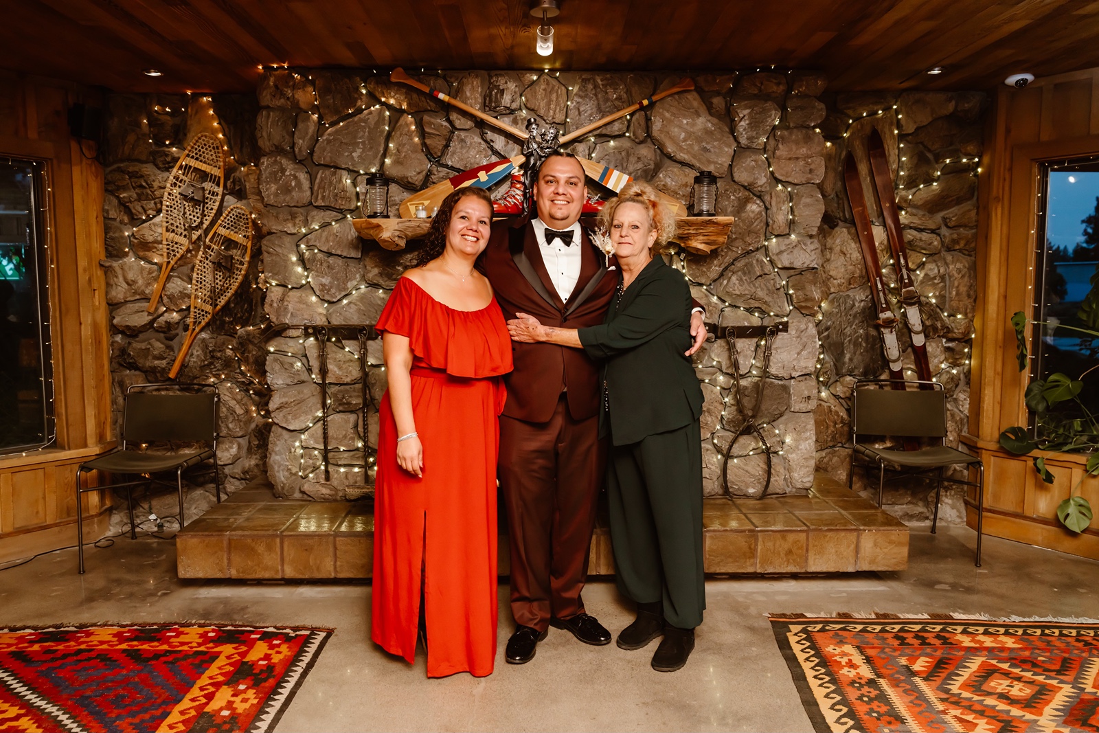 Wedding guests in front of the stone fireplace at Station House Inn