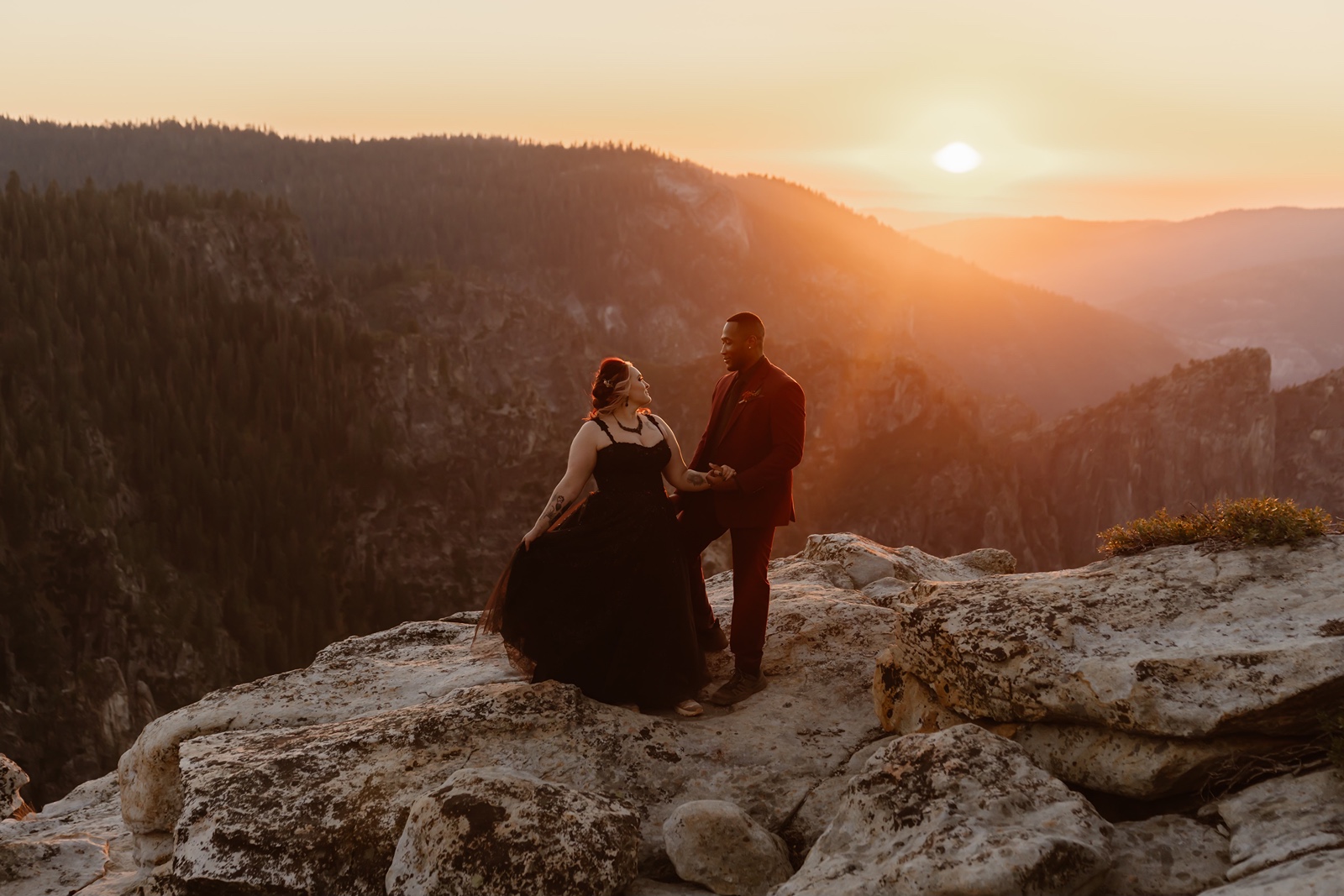 Bride in black wedding dress poses with groom as the sun sets at Taft Point