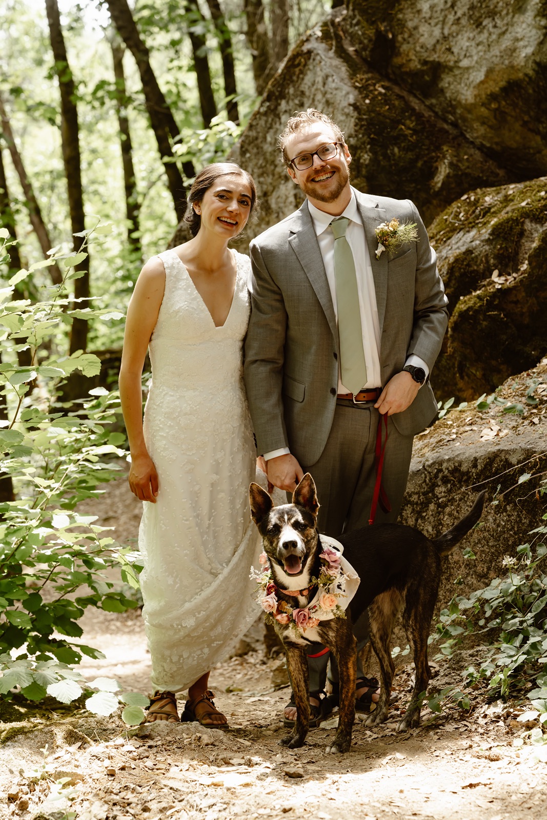 Bride and groom smile with their dog at their Miners Foundry wedding