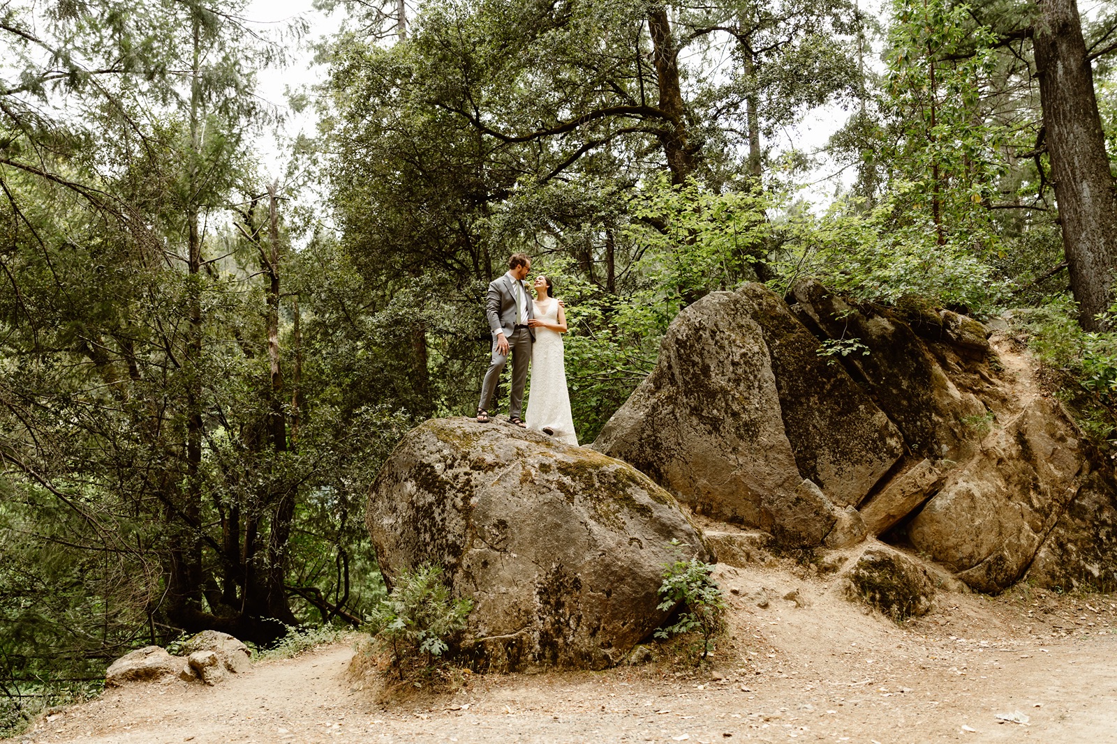 Bride and groom on a boulder at Miners Foundry