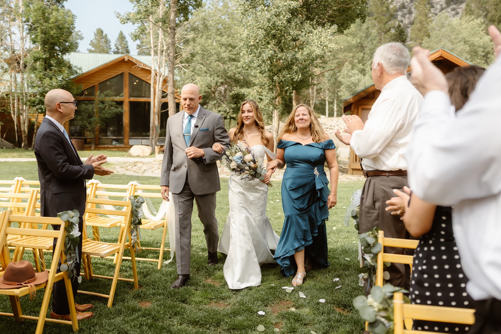 Bride walks down aisle with her parents at her Double Eagle Resort wedding ceremony