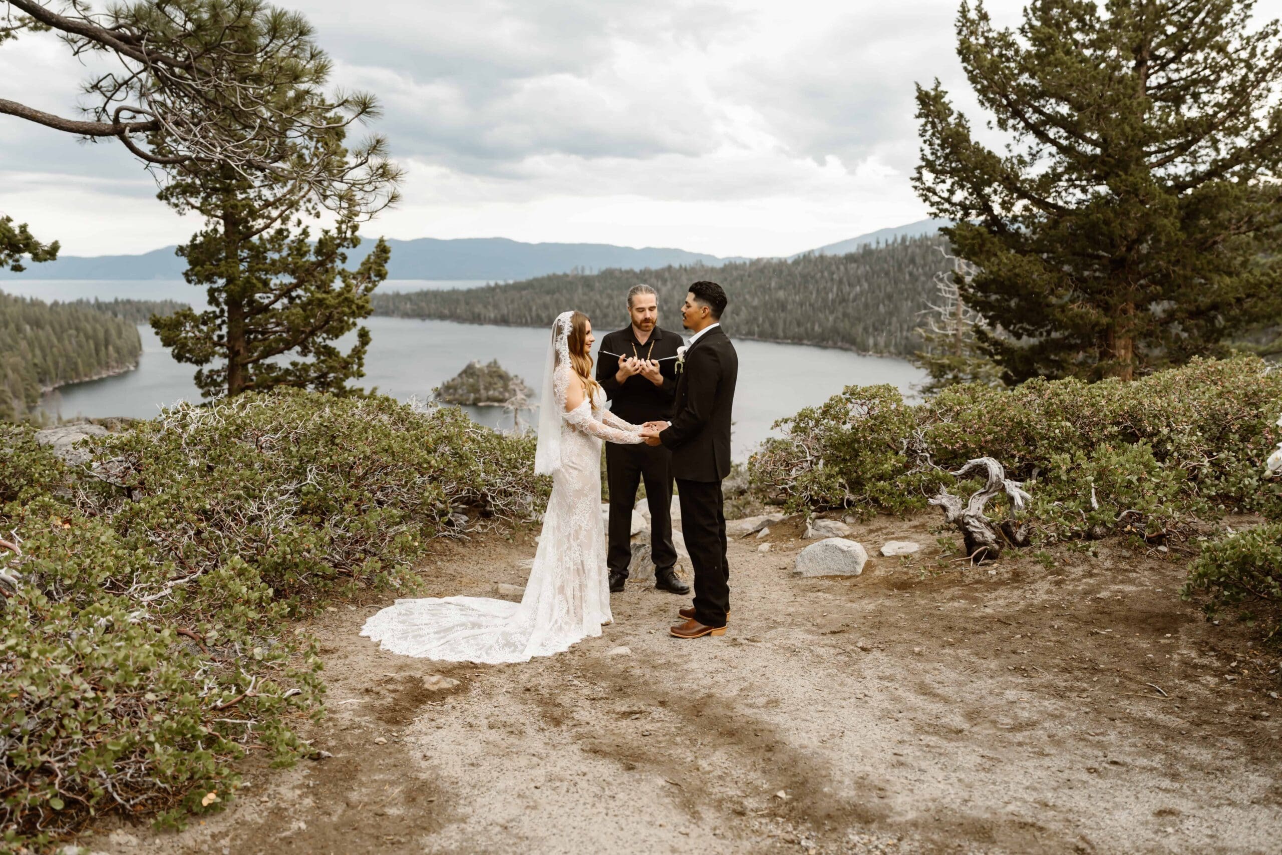 Bride and groom exchanging vows with an officiant overlooking Emerald Bay during a Lake Tahoe elopement ceremony