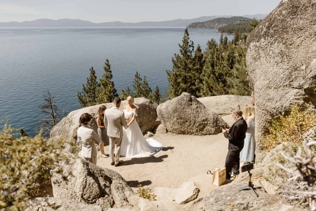 Lake Tahoe elopement ceremony at Logan Shoals with the couple exchanging vows beside granite boulders overlooking the lake.