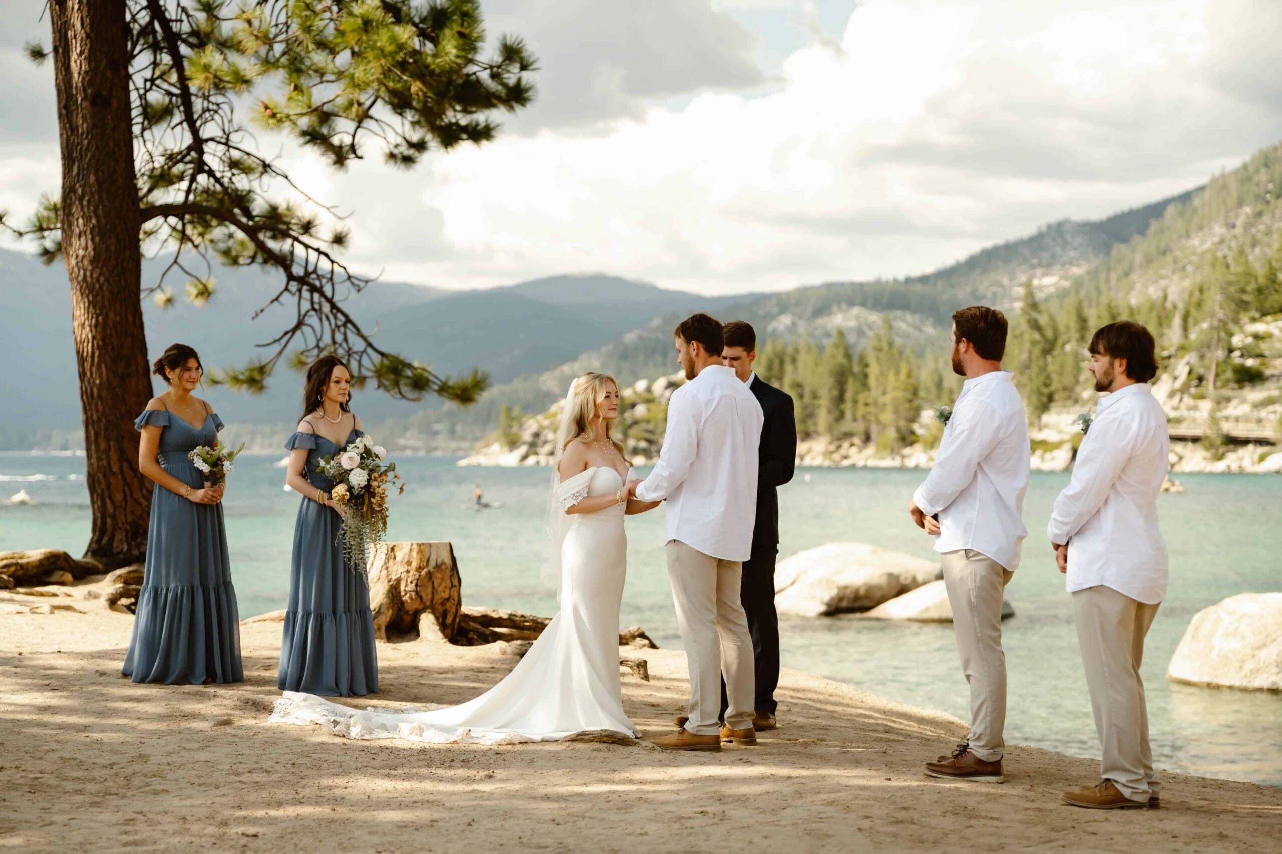 Lake Tahoe elopement ceremony at Sand Harbor with the couple exchanging vows beside the water surrounded by their wedding party.
