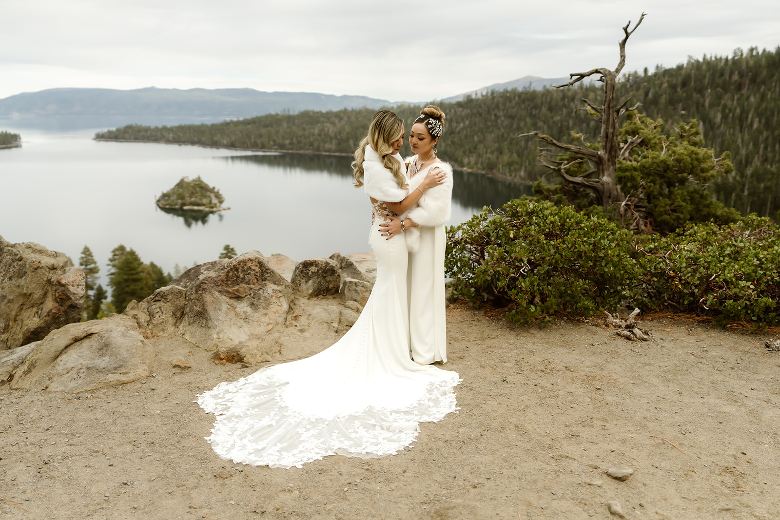 Two brides smile overlooking Emerald Bay