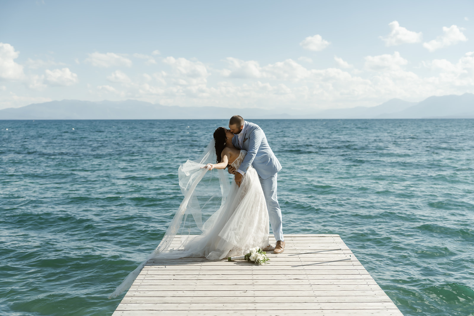 Bride and groom kiss with Lake Tahoe backdrop