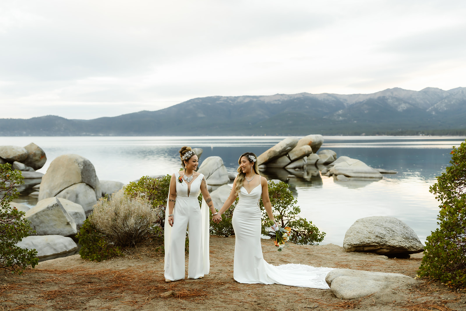 Two brides glance at each other at their LGBTQ elopement