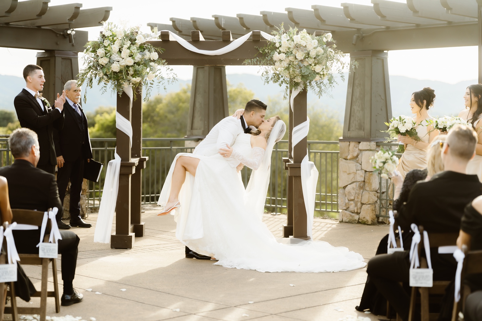 Bride and groom kiss at their outdoor Stonetree Estate wedding ceremony