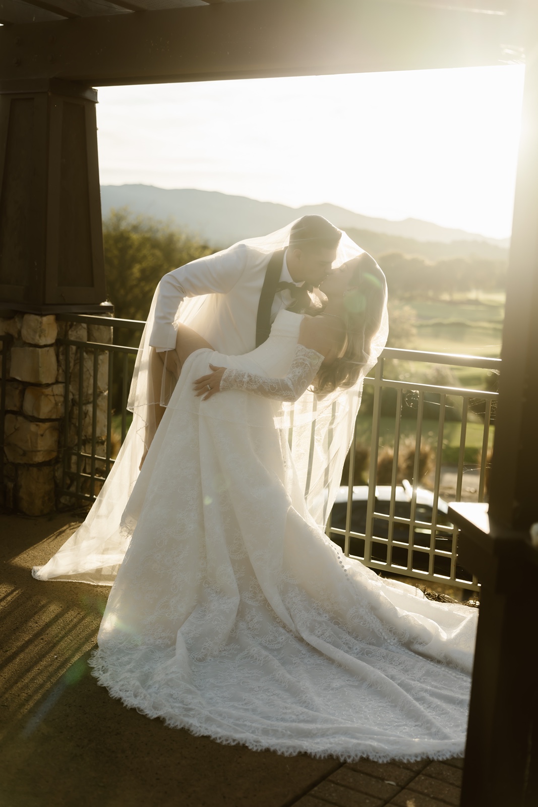 Bride and groom both under bride's veil at sunset at Stonetree Estate