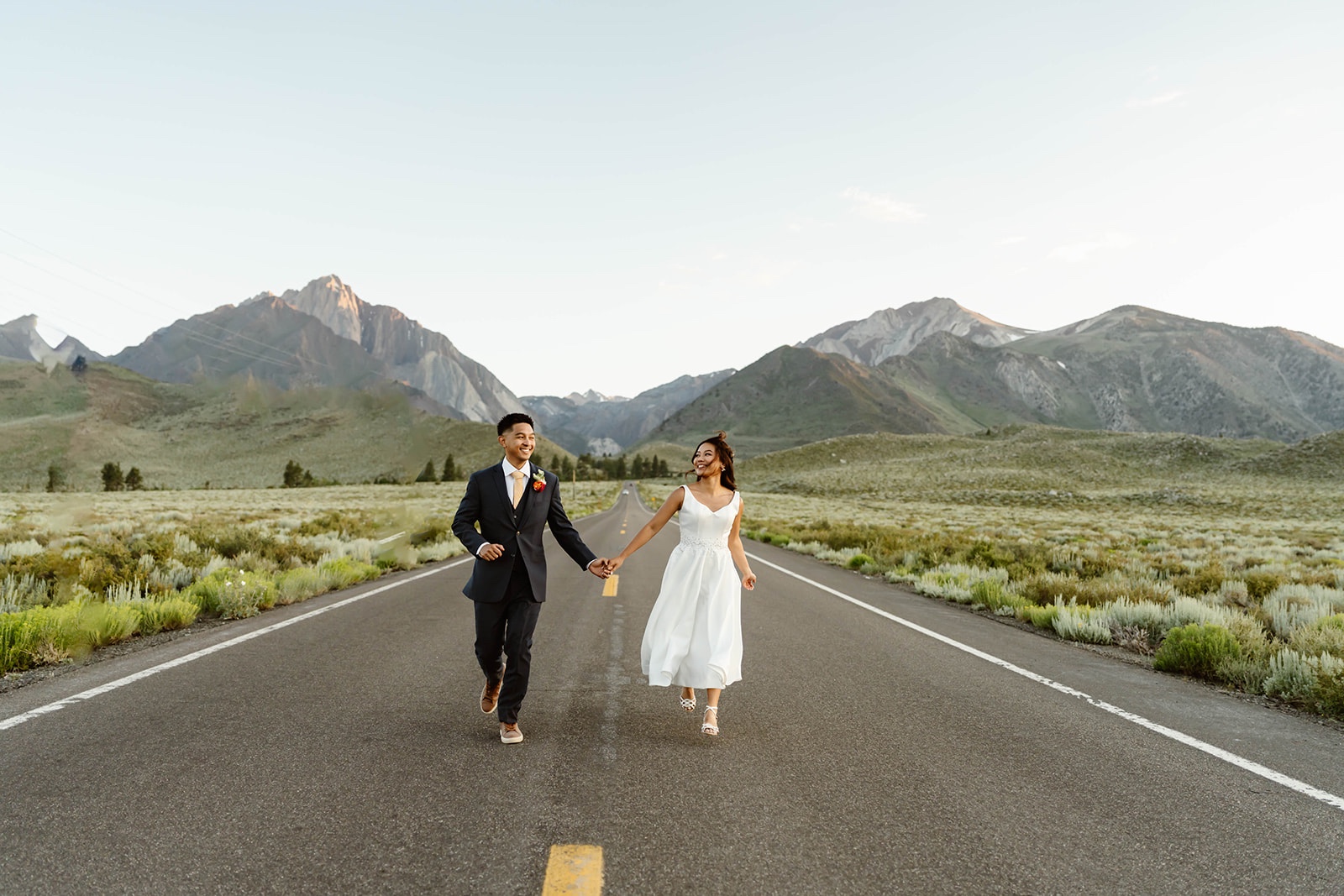 Couple holds hands at their destination elopement in the mountains