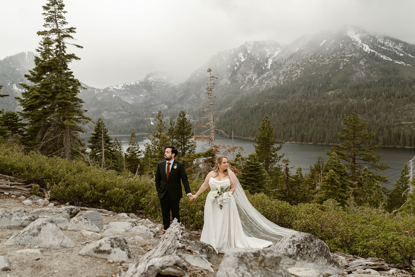 Bride an groom hold hands at their destination elopement in the mountains