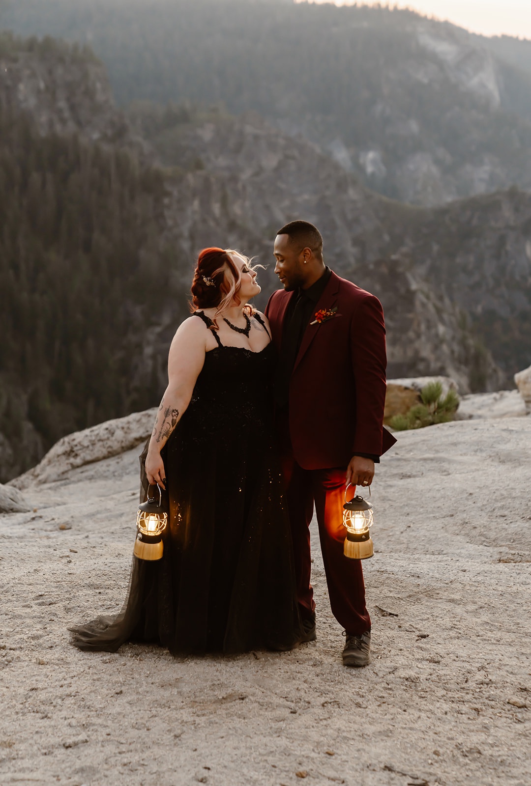 Bride and groom hold lanterns at sunset at their destination elopement